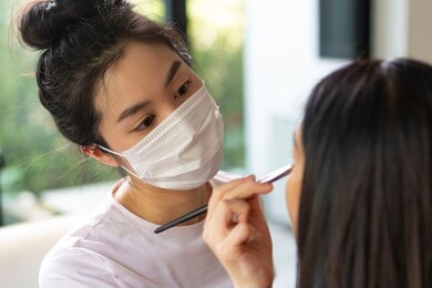 makeup artist work in her beauty visage salon. woman applying by professional makeup artist. beauty and fashion concept. make up artist doing professional make up of young woman. 