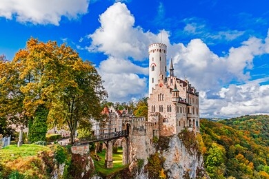 germany, lichtenstein castle in baden-wurttemberg land in swabian alps. seasonal view of lichtenstein castle on a cliff circled by trees with yellow foliage. european famous landmark.