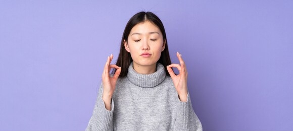 young asian woman over isolated background in zen pose