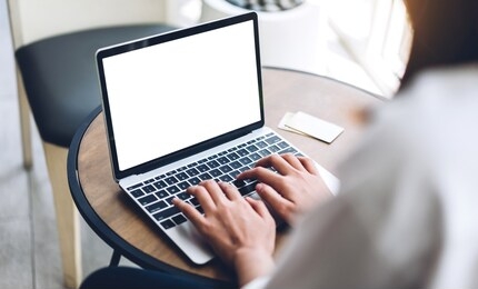 woman relaxing using technology of laptop computer with white mockup blank screens while sitting on chair in cafe and restaurant.communication and technology concept