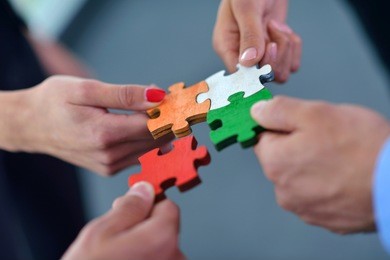 group of business people assembling jigsaw puzzle and represent team support and help concept