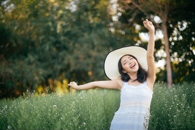 outdoor portrait of a beautiful asia woman. attractive cute girl in a field with flowers
