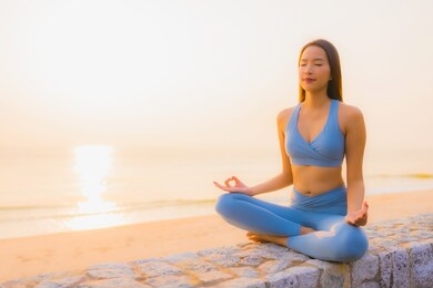 portrait young asian woman do meditation around sea beach ocean at sunrise for health
