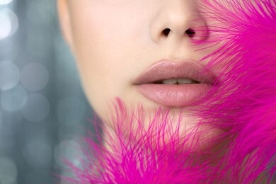 portrait of beauty model with bright color makeup. close-up lips of beautiful young woman with professional make up  and vivd pink feathers. close up, selective focus.