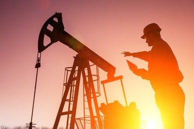 oil drill, field pump jack silhouette with setting sun and worker. lens flare. see more images and video from this series and refinery series. 