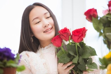 preparing to trim red and pink roses and beautiful flower arrangements in the home, flower arrangements with vase for gift-giving for valentine's day and free time in the family on the on wooden table