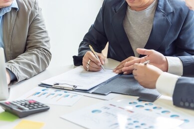 signing contracts. a group of business people sign a joint investment contract.
