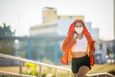 asian young fitness sport woman running  and she wears a mask for protective dust and pollution and protection flu virus, influenza, coronavirus on city 