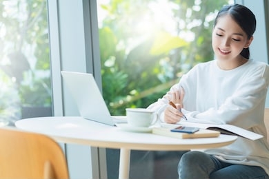 relax leisure attractive smart asian female business entrepreneur smile and enjoy working with smartphone and laptop at home with blur garden background business casual ideas concept