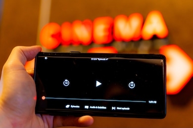 slow internet, video load and download speed. watching movie online. loading icon on screen.hand with black empty screen mobile phone . background red wall with cinema signate.