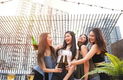group of young asian woman friends have happiness moment to celebrating dance party with bottle of beer in hand in nightclub.