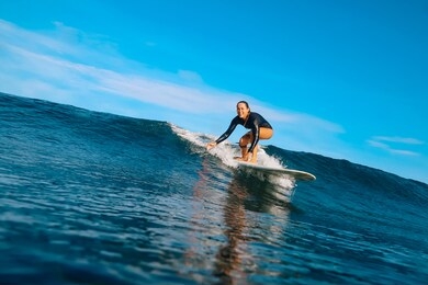 female surfer on a blue wave at sunny day