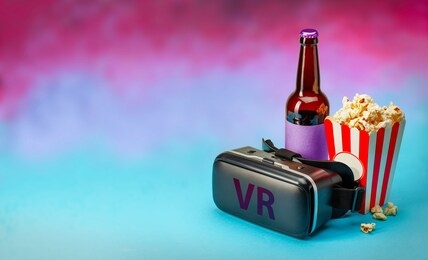 vr movie at home. vr glasses helmet and popcorn and bottle of beer on colorful background. copy space for text