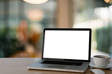 mockup image of laptop with blank white screen on glass table at outdoor with green nature background light bokeh.- image