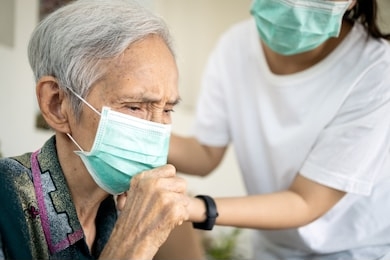 sick elderly woman with coughing and fever,risk symptoms of flu,pandemic of covid-19, asian daughter wearing protective mask to senior mother,prevent outbreak or spread of coronavirus to other people