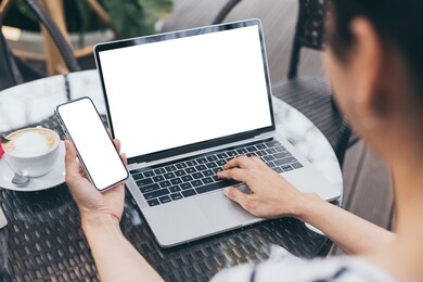 computer,cell phone mockup image blank screen with white background for advertising text,hand woman using laptop texting mobile contact business search information on desk in cafe.marketing,design