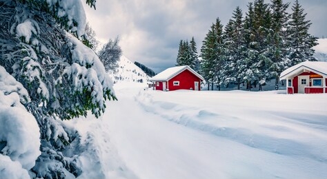 traditional norwegian red wooden houses under the fresh snow. impressive winter scene of lofoten islands on the shore of kongsjordpollen fjord, vestvagoy, norway, europe. life over polar circle.
