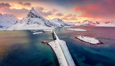 view from flying drone of lofoten islands. astonishing winter sunrise on norway, europe. aerial morning view of fredvang bridge with volandstind peak on background.  life over polar circle.