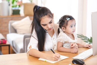 asian mother is busy and she must working while caring her daughter. problem of mother, work life balance, over working concept.

