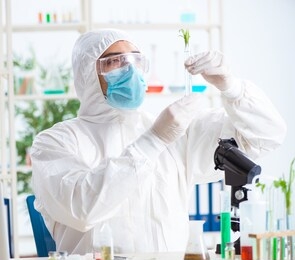 male biochemist working in the lab on plants