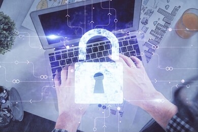 multi exposure of man's hands typing over computer keyboard and lock hologram drawing. top view. technology concept.