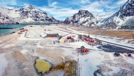 view from flying drone of flakstad village with hustinden mount on background, norway, europe. breathtaking spring scene of lofoten islands. impressive morning landscape with flakstad church.