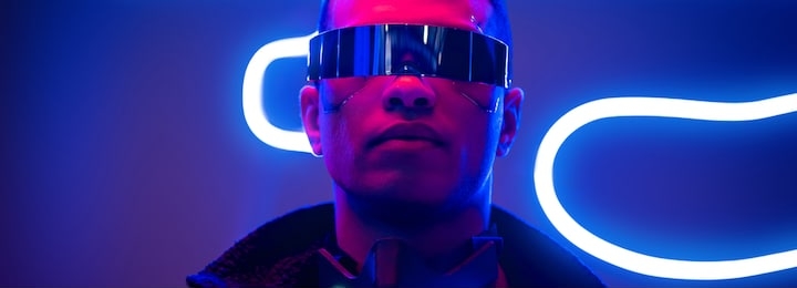panoramic shot of mixed race cyberpunk player in futuristic glasses near blue neon lighting