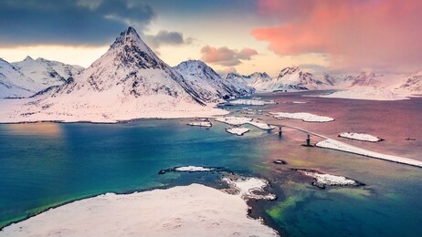 fabulous winter sunrise on norway, europe. view from flying drone of lofoten islands archipelago. colorful morning view of fredvang bridge with volandstind peak on background. life over polar circle.
