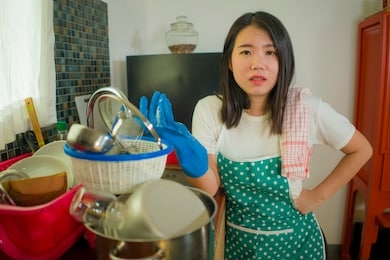 cook and wash overwork - young tired and stressed asian chinese woman in kitchen apron working at home exhausted and desperate complaining frustrated and overwhelmed