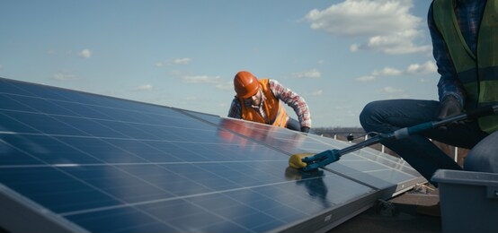 medium shot of technicians cleaning and maintaining solar panels
