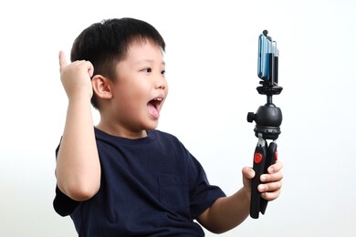 portrait of confident and creative asian child blogger talking on camera in a studio, he make video blog. online influencer vlogger children boy social media live steaming concept.