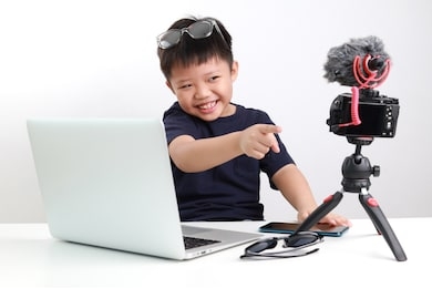 portrait of confident and creative asian child blogger talking on camera in a studio, he make video blog. online influencer vlogger children boy social media live steaming concept.