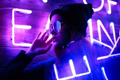 phantom blue 2020 trend.portrait of a girl on the background of a neon sign of a shop window 
