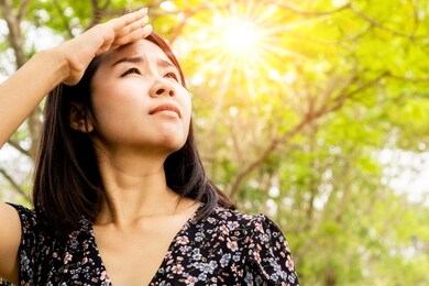 asian woman having problem sunburn ,melasma, freckles on skin, hand cover her face to protect uv sunlight 
