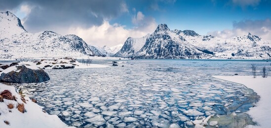 incredible winter scene over polar circle. frozen boosen fjord on flakstadoya island. panoramic morning view of lofoten islands with hustinden mountain on background, norway, europe.