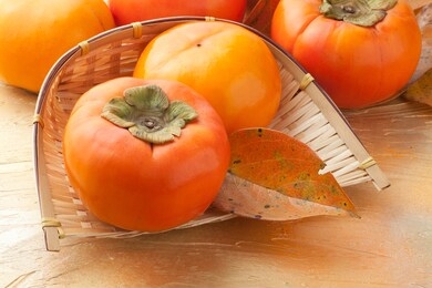 fresh orange organic ripe fuyu persimmon on light background.