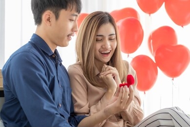 young and smile face asian man giving and opening ring box for his lover young and beautiful pretty woman while she very happy and excited face. concept for love, sharing time and ask for wedding.