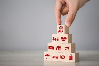 hand arranging wood block stacking with icon insurance: car,