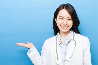 doctor woman with stethoscope showing copy space, against blue background. 