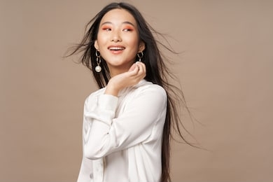 beautiful woman asian appearance bright makeup luxury smile model beige background