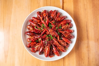 a large bowl of delicious braised crayfish on a wooden table	
