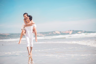 copy-spaced image of a cheerful young couple piggybacking on the beach 