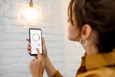 controlling light bulb temperature and intensity with a smartphone application. concept of a smart home and managing light with mobile devices