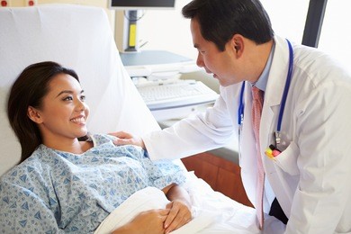 doctor talking to female patient on ward