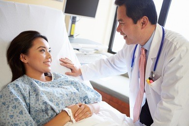 doctor talking to female patient on ward