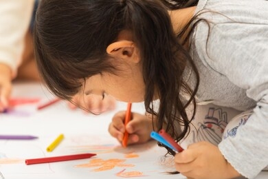 a child drawing on a large drawing paper