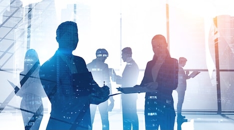 concept of communication and business partnership. silhouettes of diverse business people in panoramic office with double exposure of abstract cityscape.toned image