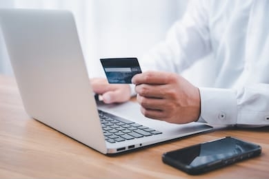 hand holding credit card and using laptop. businessman or entrepreneur working from home. online shopping, e-commerce, internet banking, spending money, work from home concept.