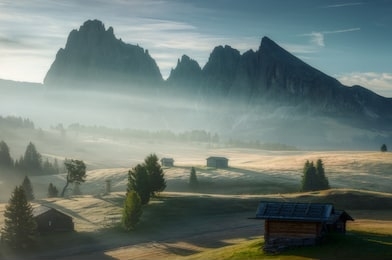 a vertical panorama shot of the highest plateau on the mountain during the foggy morning and an early sunrise with many sun rays lighting the pastures 