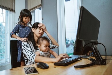 stress mother while working from home and babysitting her children